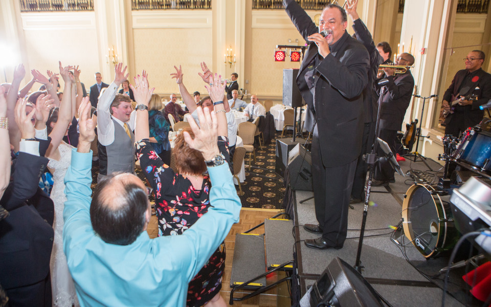 Band members singing and audience dancing