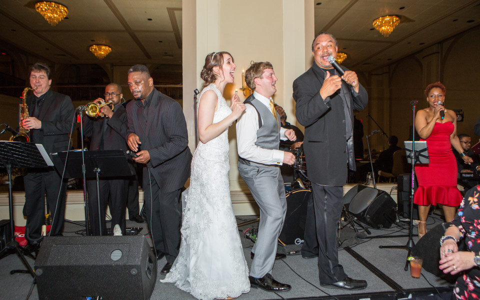 newlyweds on stage with Carl the bandleader and band members